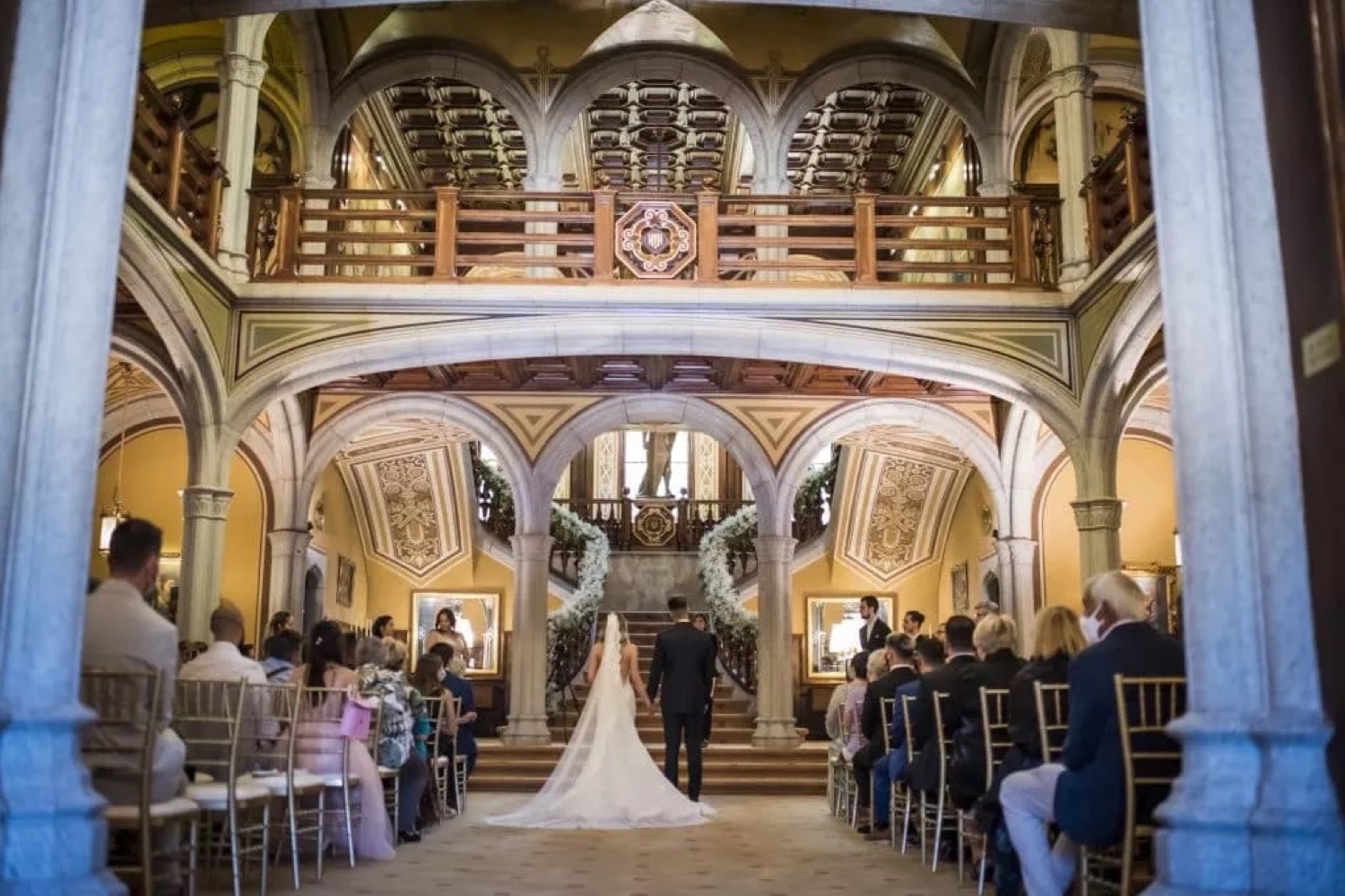 A bride walking down the aisle in the hall of Bell Reco on the Costa Brava, with guests seated