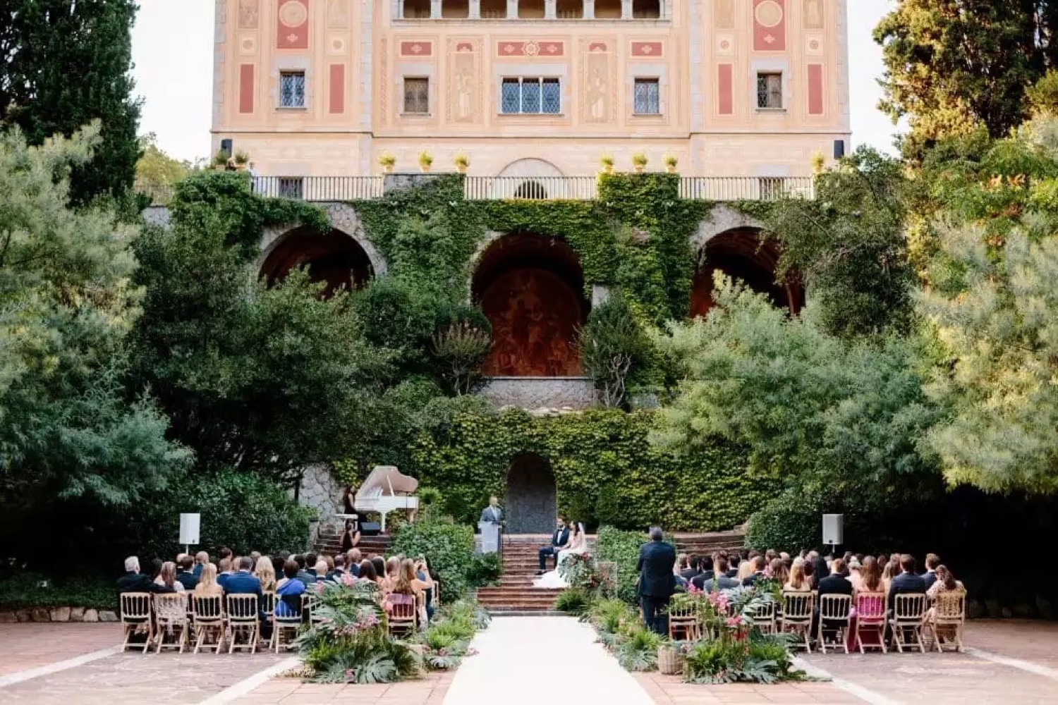 A ceremony in the gardens of Bell Reco on the Costa Brava, with guests seated and the house behind