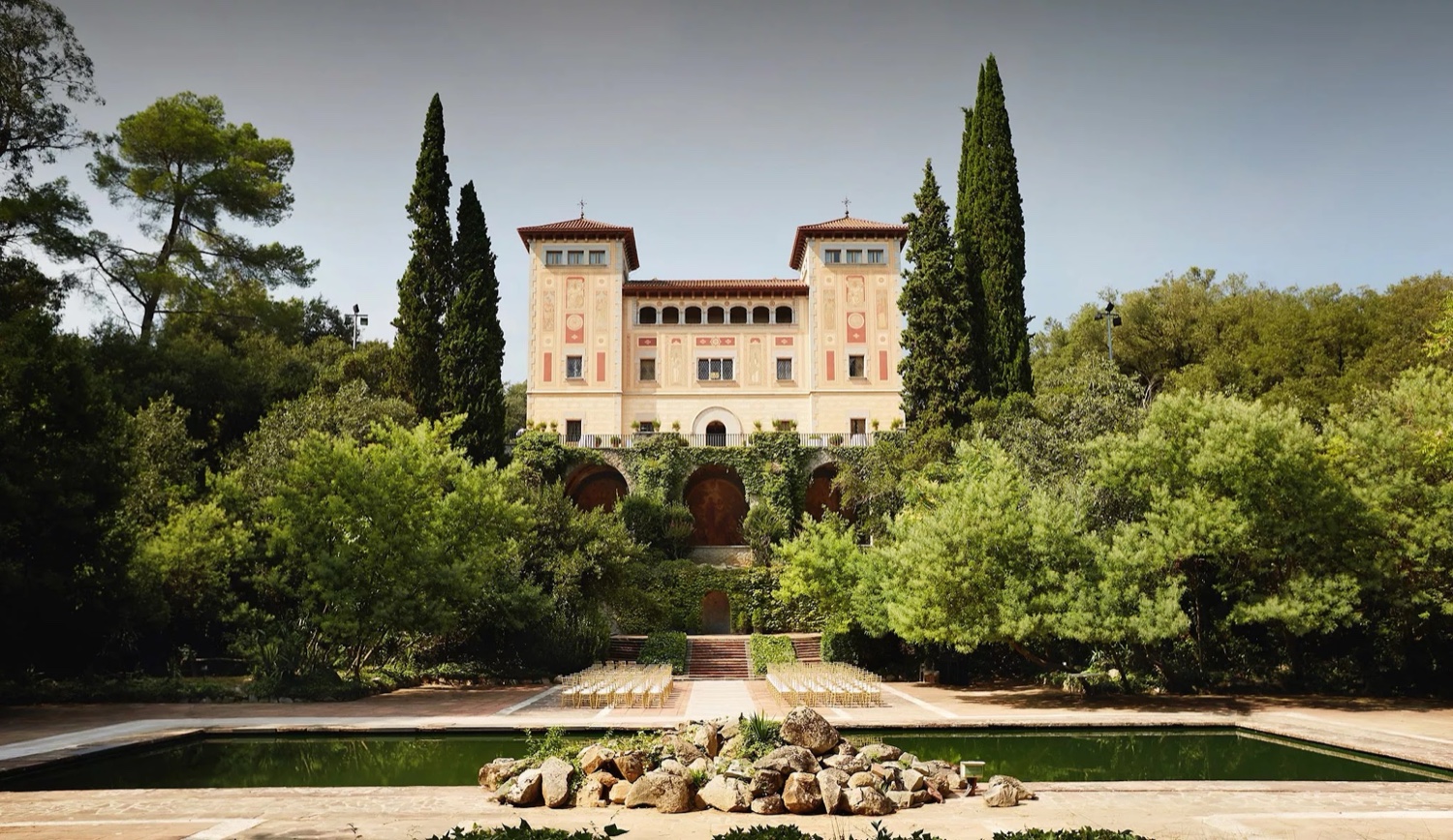 The masia of Bell Reco in the Costa Brava countryside, seen across its gardens and a pool