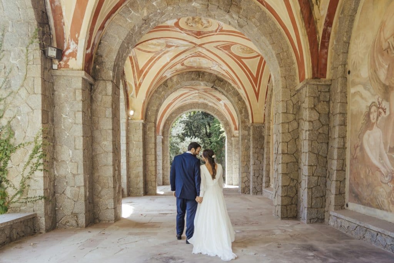 A couple walking through a vaulted stone gallery at Bell Reco on the Costa Brava