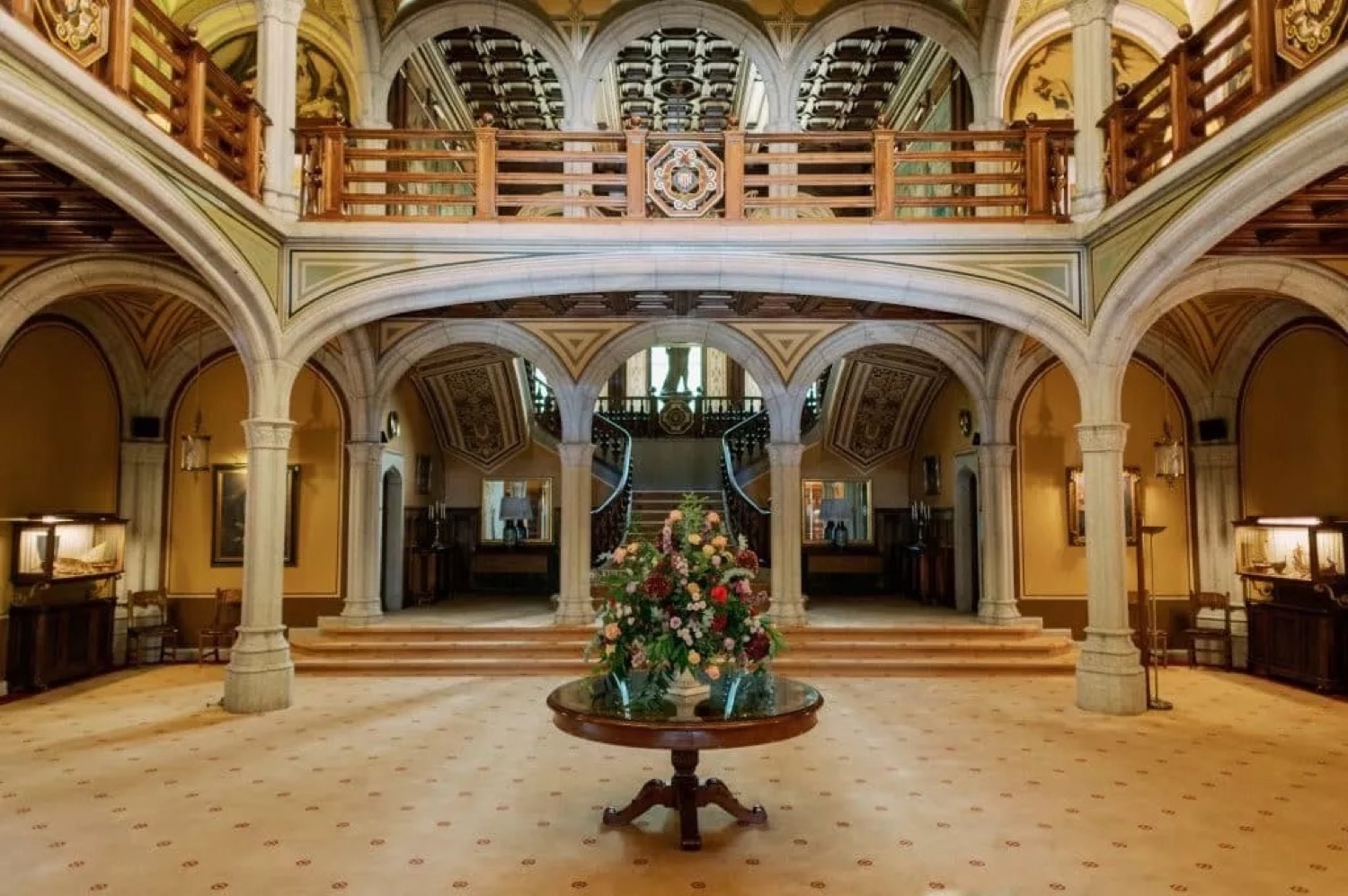 The vaulted hall of Bell Reco on the Costa Brava, with a wooden gallery and a round table of flowers