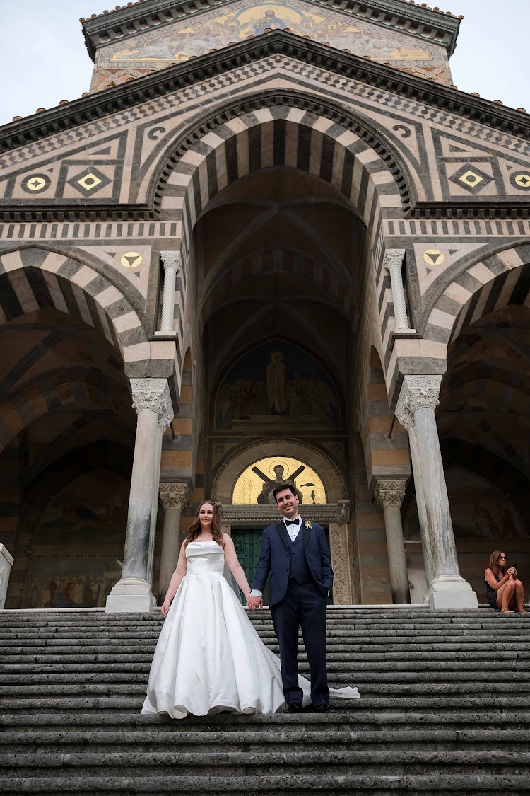Couple standing on the steps of Amalfi Cathedral during their elopement photo stop in Amalfi, Italy