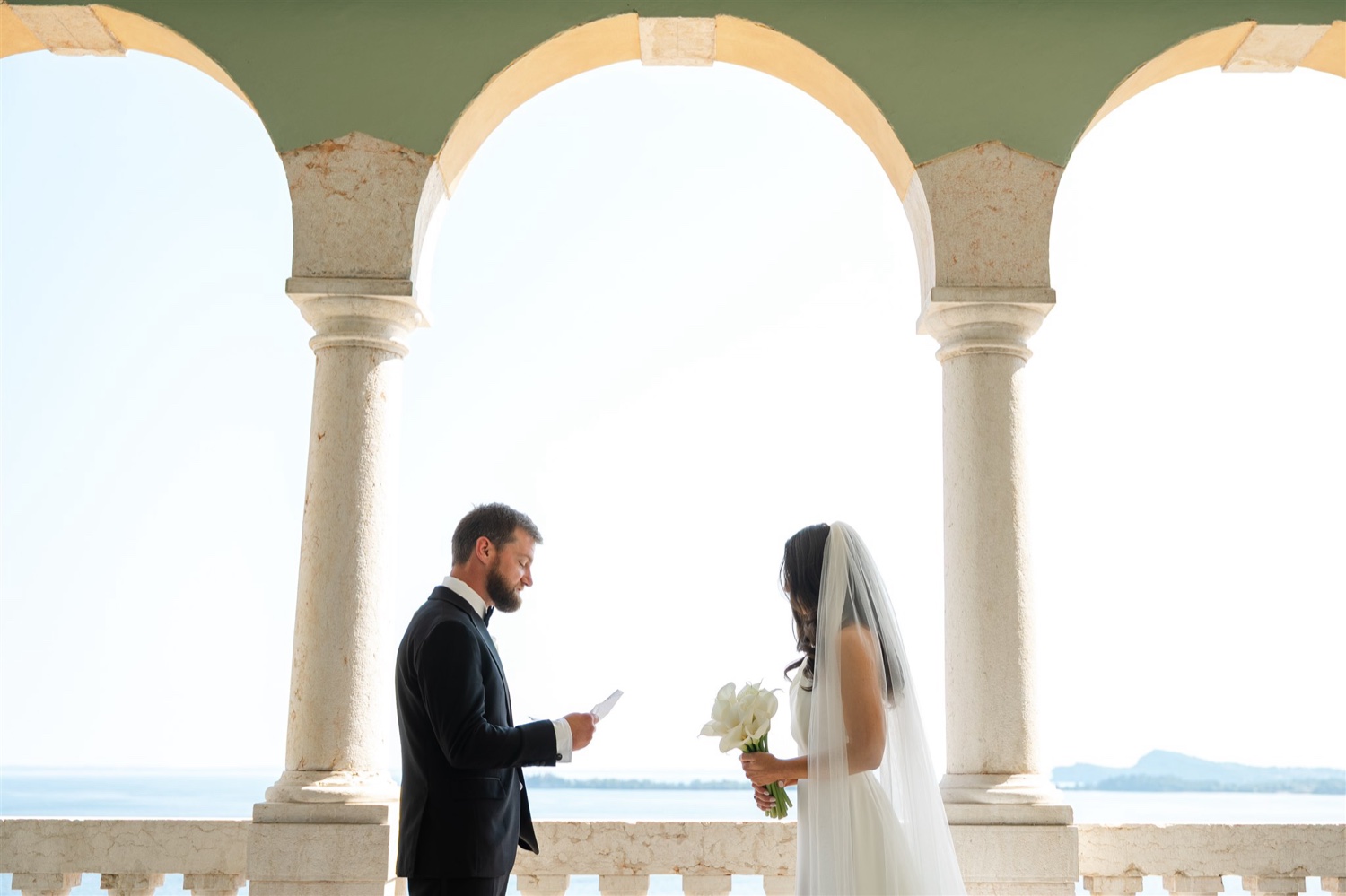 A groom reading his vows to his bride on the arched terrace of Villa del Sogno on Lake Garda