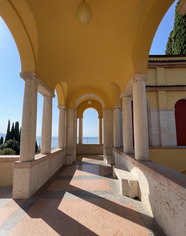 The arched terrace of Il Vittoriale with soft light and a view of Lake Garda, Italy