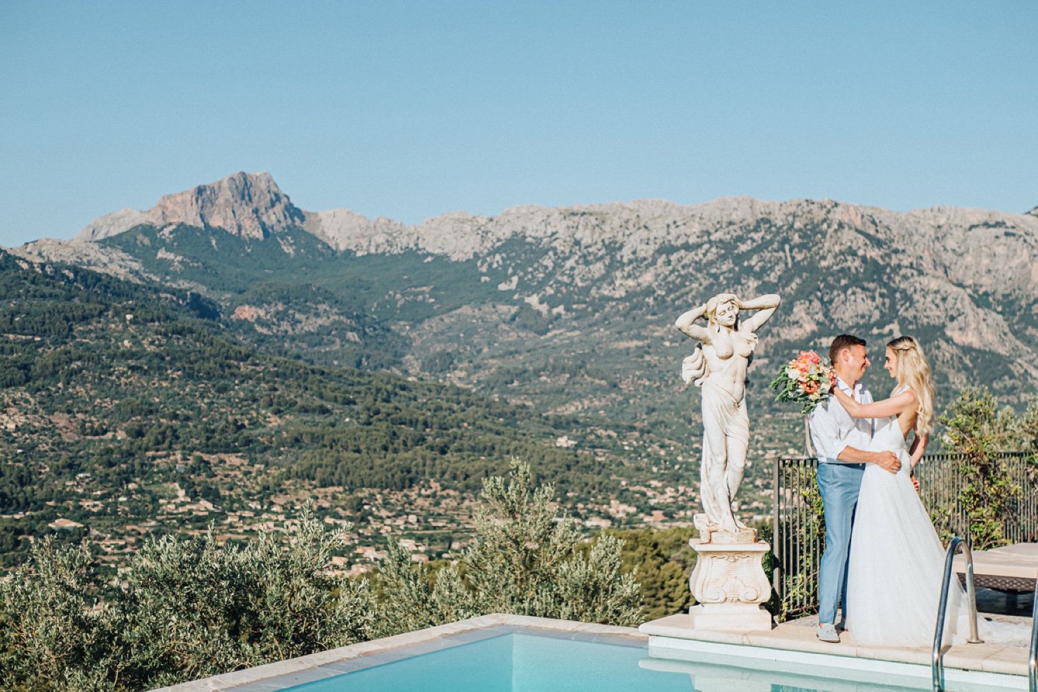 A marble statue beside the pool at Ca’s Xorc, with the mountains of Mallorca behind