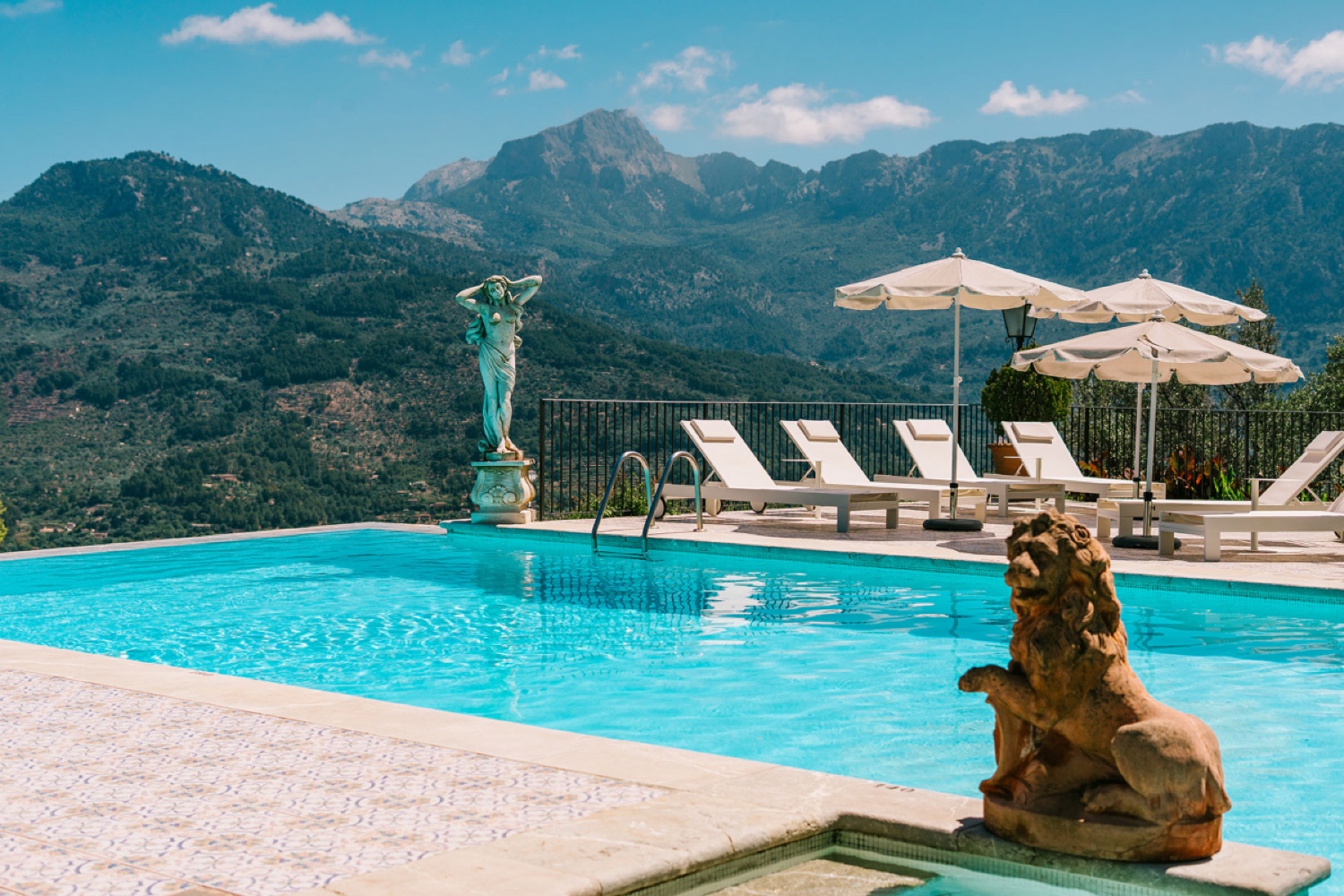 The pool at Ca’s Xorc with sun loungers and the mountains of Mallorca behind