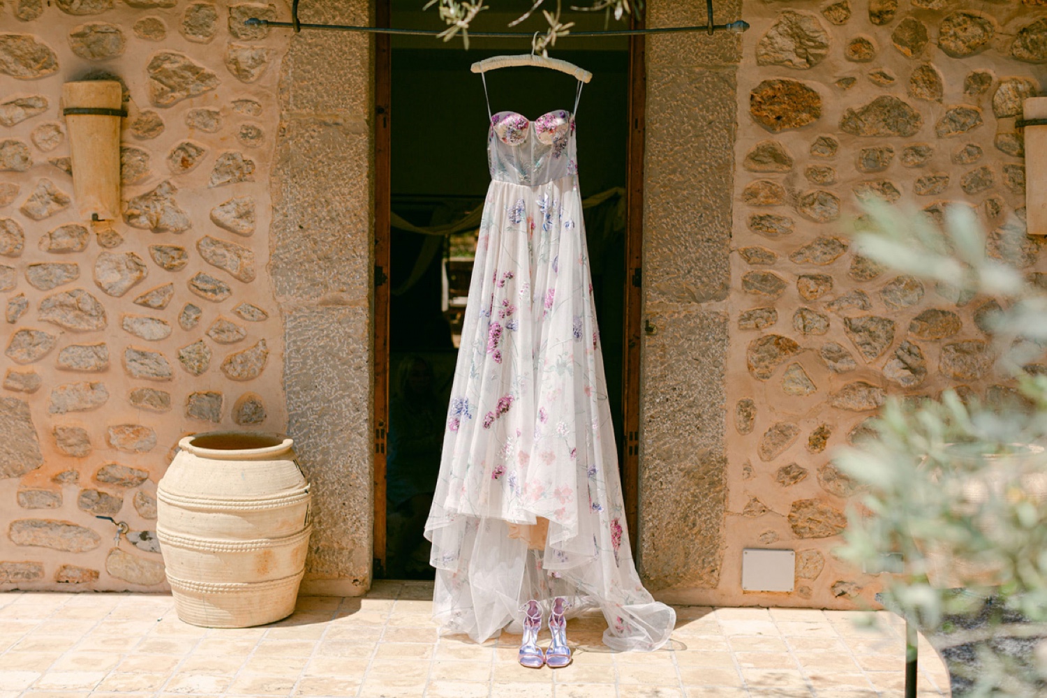 A wedding dress hanging in a stone doorway at Ca’s Xorc in Mallorca